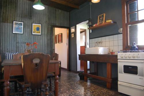 - une cuisine avec une table, une cuisinière et un comptoir dans l'établissement Altaves, à San Clemente del Tuyú