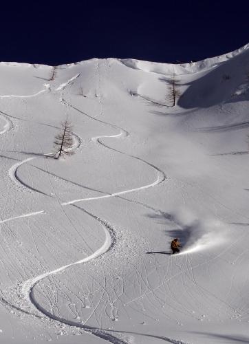 a person riding a snowboard down a snow covered slope at Haus Brandner in Tröpolach