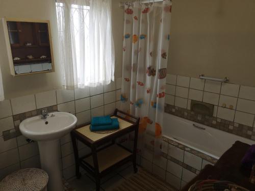 uma casa de banho com um lavatório, um chuveiro e uma banheira em Cassiandra Place unit 1 em Richards Bay