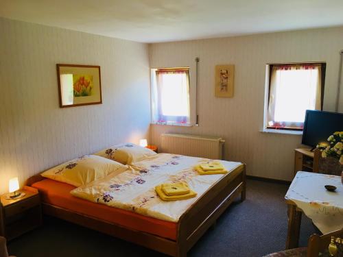 ein Schlafzimmer mit einem Bett mit gelben Handtüchern darauf in der Unterkunft Ferienwohnung Hänel in Hinterhermsdorf