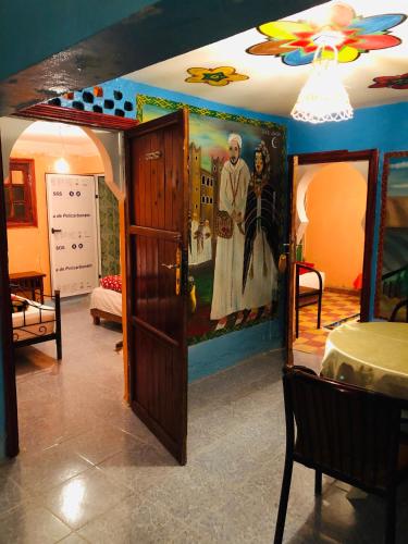 a room with a painting on the wall and a door at Auberge des lacs in Imilchil