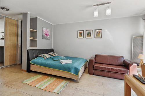 a bedroom with a bed and a couch at Apartament Magnolia Centrum Taras in Zakopane