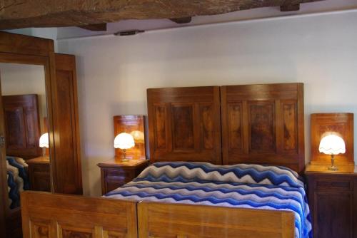 een slaapkamer met een groot houten bed met blauwe lakens bij Vinco in Castel del Rio