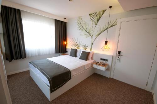 a bedroom with a bed and a large window at Luis Otel in Izmir