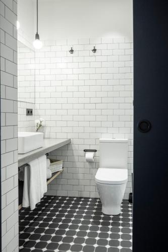 a white bathroom with a toilet and a sink at Talo Urban Rooms in Donostia-San Sebastián