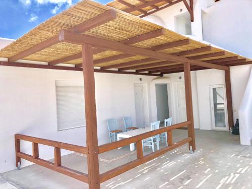 a pergola on a patio with a table and chairs at New Paradise in Mikonos