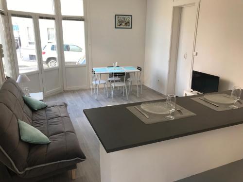 un salon avec un canapé et une table dans l'établissement Studio 50m Plage, à Dunkerque