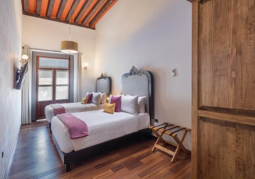 a bedroom with two beds in a room at Hotel Casa Monarca in Puebla