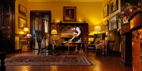 a man standing in a room with a table at Ballynahinch Castle Hotel in Ballynahinch