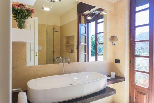 łazienka z umywalką i dużym lustrem w obiekcie Villa Gabriella - Mondello w mieście Mondello