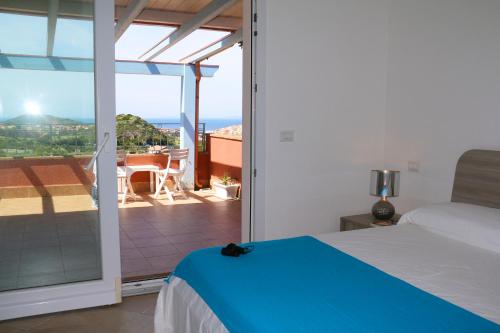 a bedroom with a bed and a view of a balcony at SARDINIA RE - Attico Baja Ostina in Castelsardo