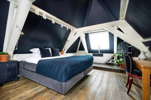 a bedroom with a bed and a desk and a window at Anne&Max Boutique Hotel in Utrecht