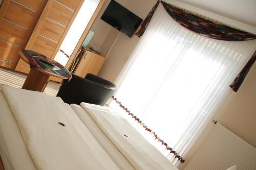 a bedroom with a bed and a window with curtains at Wein- und Gästehaus Binz-Meyer in Lieser