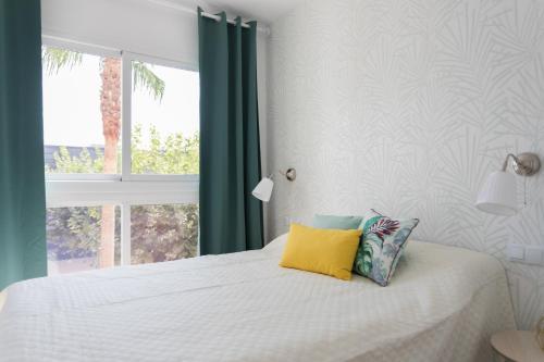 En eller flere senge i et værelse på Playa albir Beach Apartament