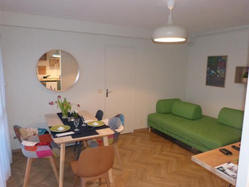 - un salon avec une table et un canapé vert dans l'établissement LA SAPINIERE, à Cabourg