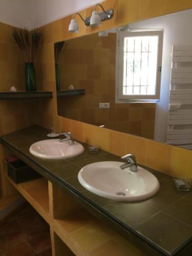une salle de bain avec deux lavabos et un miroir dans l'établissement Les Vignes de Terrisse, à Entrecasteaux