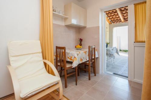 eine Küche und ein Esszimmer mit Tisch und Stühlen in der Unterkunft Apartment Petra in Brodarica