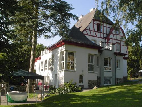 a large white house with a black roof at Waldhotel Forsthaus Remstecken in Koblenz
