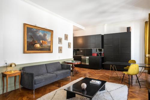 un salon avec un canapé et une table dans l'établissement HONORÊ - Suite Victor Hugo, à Lyon