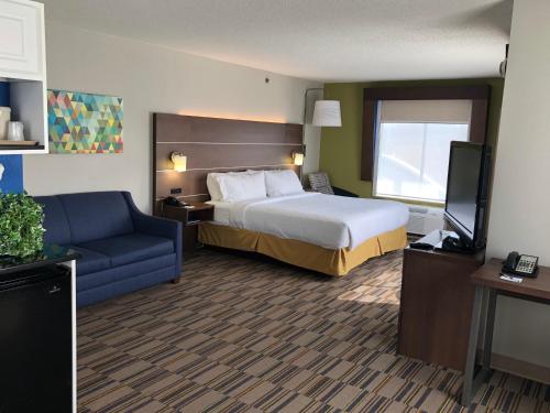 a hotel room with a bed and a blue couch at Holiday Inn Express and Suites - Quakertown, an IHG Hotel in Quakertown