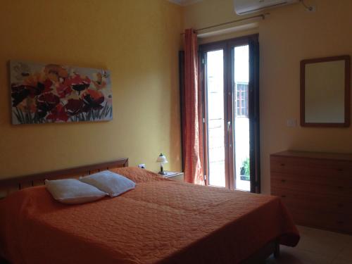 1 dormitorio con cama y ventana en Ampio appartamento Sulcis Iglesiente Sardegna, en Gonnesa