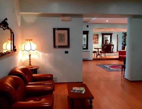 a living room with a leather couch and a lamp at Domus Salentina in Leverano