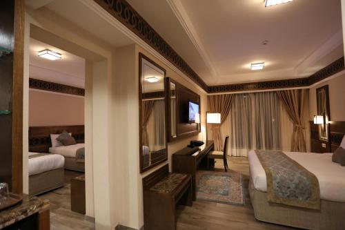 a hotel room with a bed and a desk at Violet Al Azizia Hotel MASJID Al Qatari in Makkah