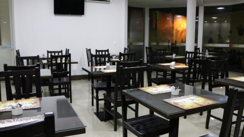 a dining room filled with tables and chairs at Café Palace Hotel in Três Pontas