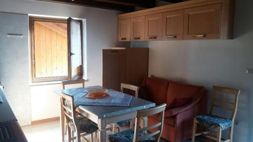 een keuken met een tafel en stoelen en een tafel en een tafel en een keuken bij il Nido in Tonadico