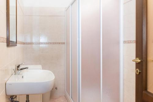 a white bathroom with a sink and a shower at Casa Del Grande Vecchio in Airasca