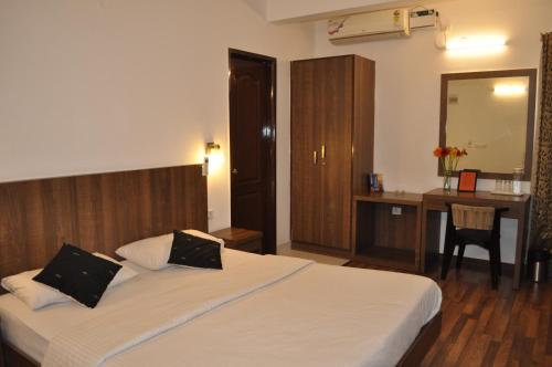 a bedroom with a bed with a desk and a mirror at Thyme the Transit in Bangalore