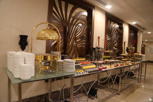 a buffet line with food on a glass table at Violet Al Azizia Hotel MASJID Al Qatari in Makkah