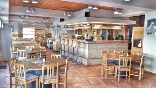 un restaurant avec des tables et des chaises en bois et un comptoir dans l'établissement Pension Relax, à Pec pod Sněžkou