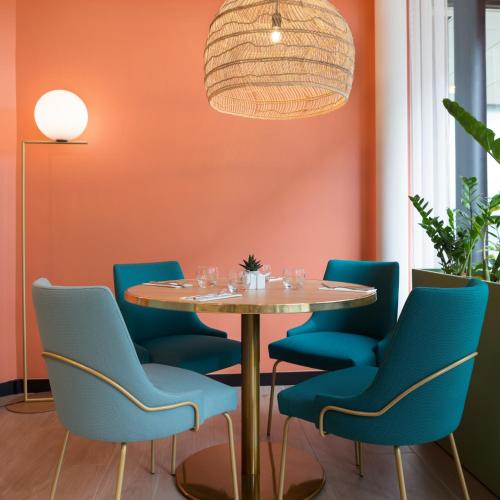 a dining room with a table and blue chairs at Novotel Paris Charles de Gaulle Airport in Roissy-en-France