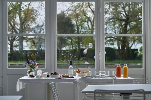 a dining room with two tables and a window at CHASSE-SPLEEN Les Chambres in Moulis-en-Médoc