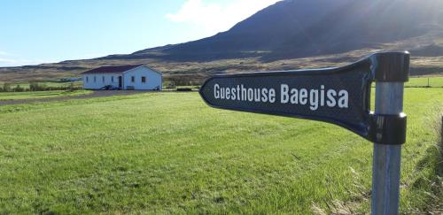 a sign on the side of a grassy field at Guesthouse Baegisa in Akureyri