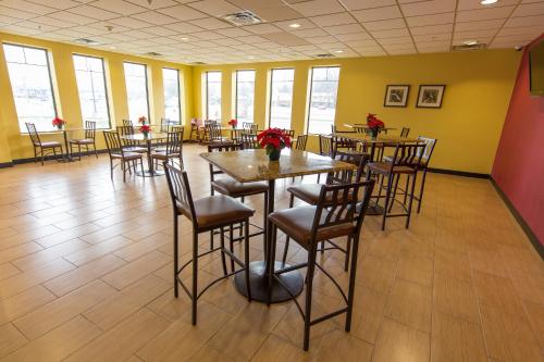 a restaurant with tables and chairs in a room with yellow walls at Rodeway Inn in Portage