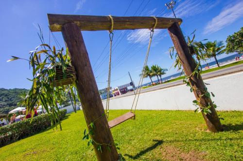 a swing on the grass near the beach at Hotel VillaReal Guaratuba - Caieiras in Guaratuba