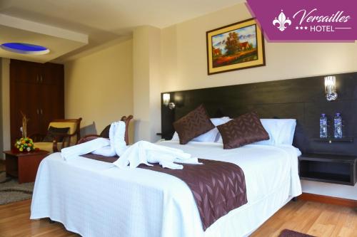una habitación de hotel con una cama con un cisne en ella en Hotel Versailles, en Ambato