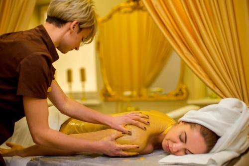 a man giving a girl a massage in a hospital room at Atostogų Parkas Hotel in Palanga