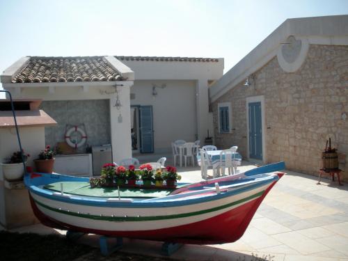 a boat with flowers on the front of a house at Casa vacanze La Meridiana in Donnalucata