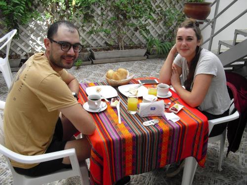 un hombre y una mujer sentados en una mesa en Kelebek Hostel en Lima