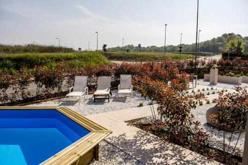a swimming pool in a yard with chairs and plants at Home Suites Home in Salionze