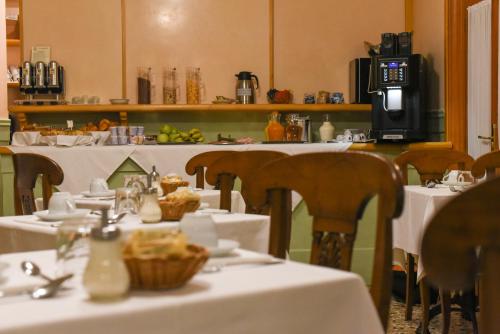 un comedor con mesas y sillas con mantel blanco en Palazzo Cendon Piano Antico, en Venecia