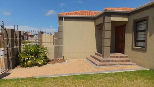 uma pequena casa com um portão e uma cerca em B.R.O.Homes and Villas em Port Elizabeth