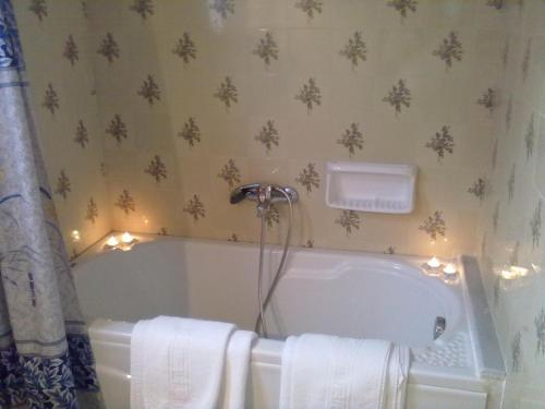 a bathroom with a tub with lights on the wall at Triantafyllia's House in Agios Ioannis Pelio