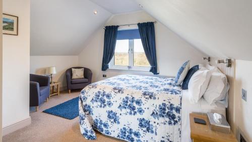 a bedroom with a blue and white bed and a window at Canaston Oaks in Narberth