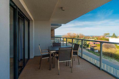 a balcony with a table and chairs and a view at Apartamenty Sun Seasons 24 - Gardenia in Dziwnów