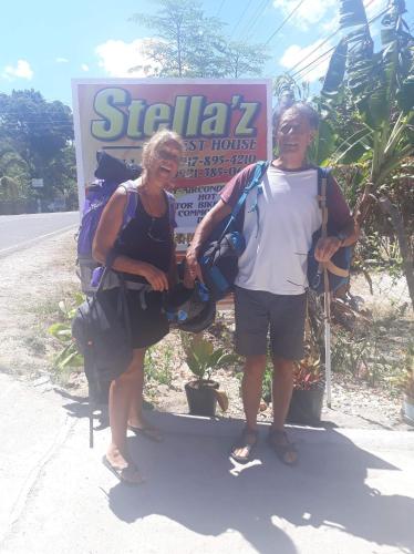 two people standing in front of a sign at Stella'z guesthouse in Siquijor