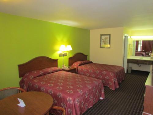 ein Hotelzimmer mit 2 Betten und einem Tisch in der Unterkunft Red Carpet Inn - Augusta in Augusta